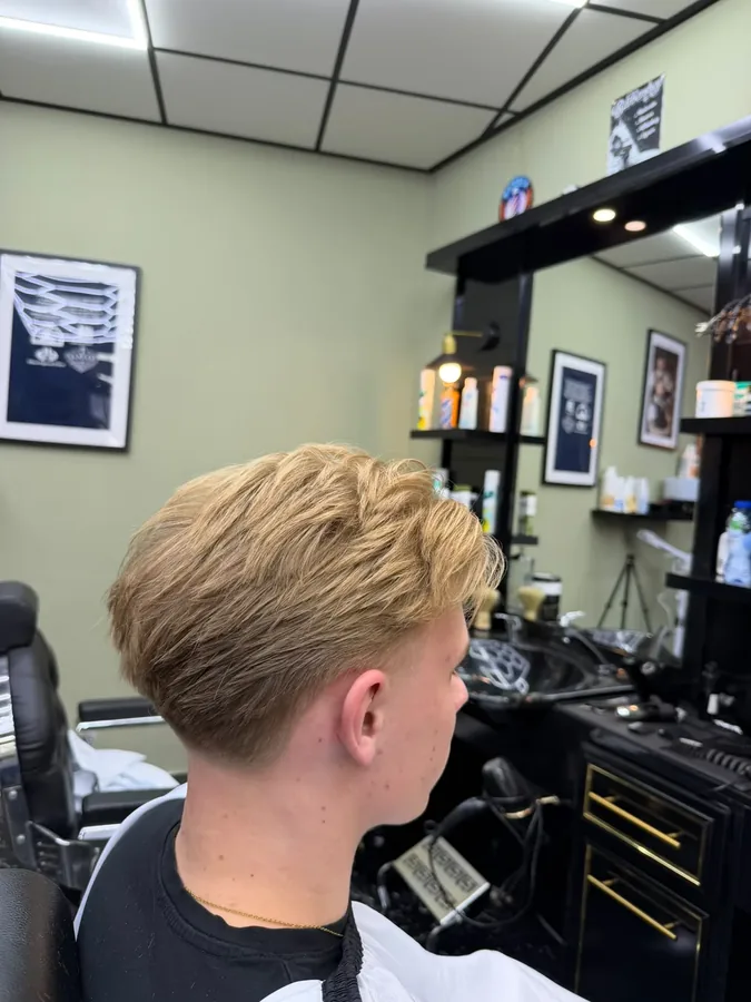 Blond haar met een lange, getextureerde bovenkant en een lage fade