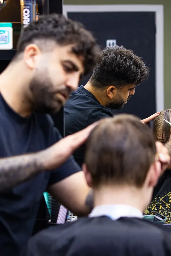 Barbier knipt een klant in de barbershop van Barzan Barbers