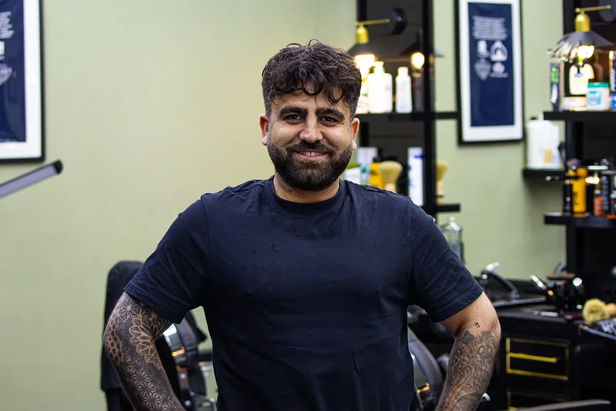 Lachende barbier in de barbershop van Barzan Barbers in Emmen